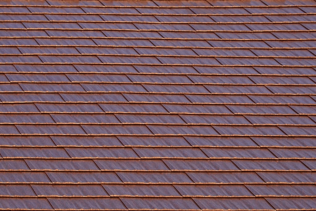 Aged Copper Interlock Cedar Shingle aluminum roof on a brown two-storey home with dormers in a suburban, Burien, Washington