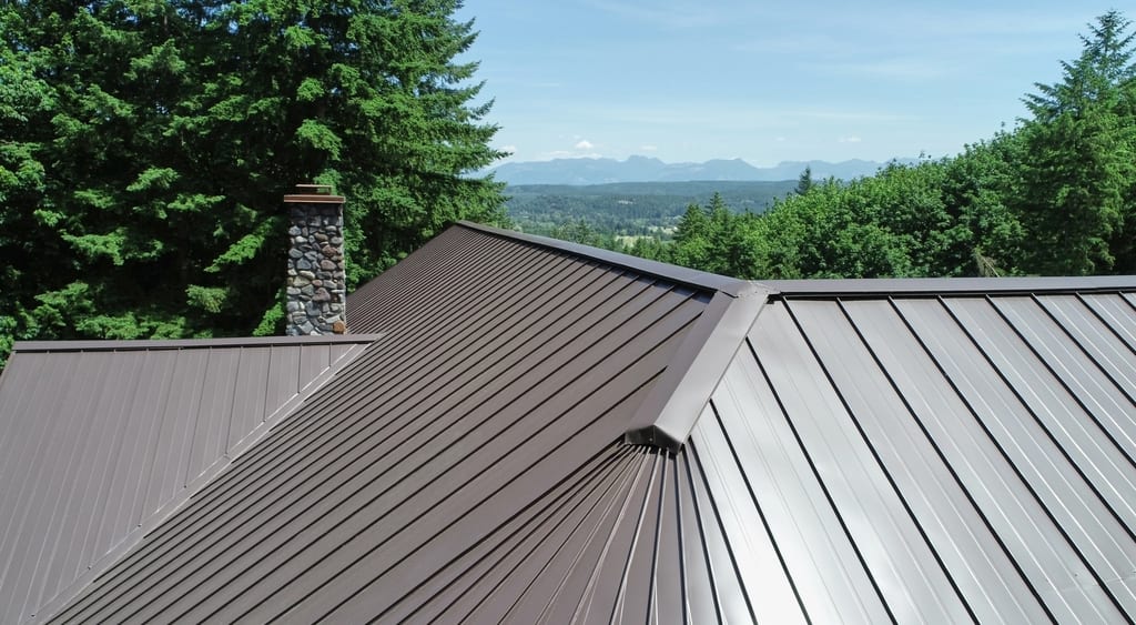 Tudor Brown Interlock Standing Seam aluminum roof on a Tudor-style home with a metal roof in a forested setting, Fall City, Washington