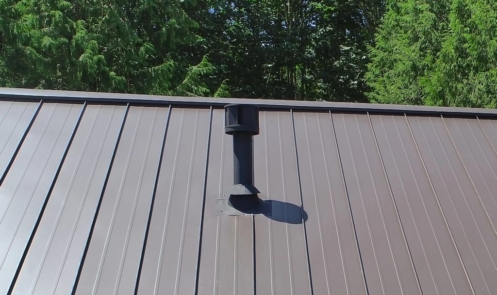 Tudor Brown Interlock Standing Seam aluminum roof on a brown two-storey Tudor home with dormers among tall, Fall City, Washington