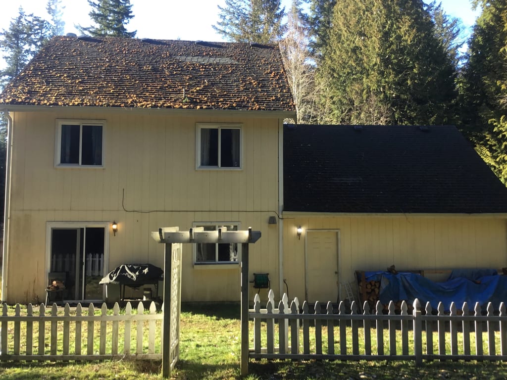 Before: a worn out asphalt shingle roof on the home, Poulsbo, Washington, ahead of a Black Interlock Slate aluminum roof