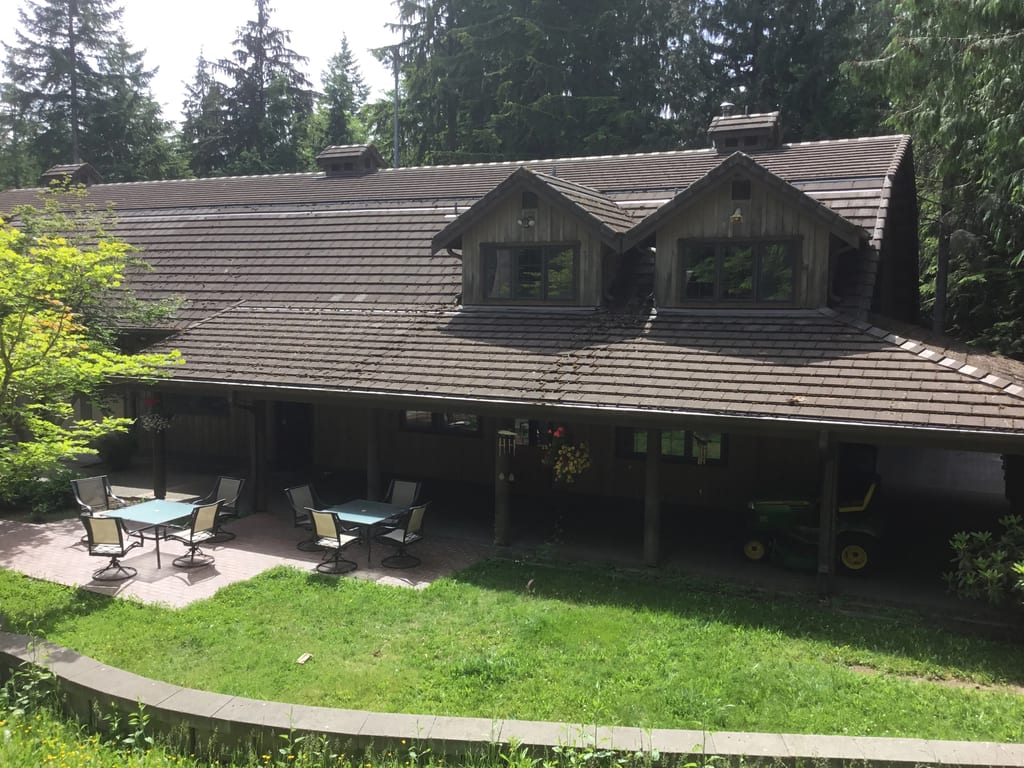 Before: a concrete tile roof with broken tiles on the home, Preston, Washington, ahead of a Hunter Green Interlock Standing Seam aluminum roof
