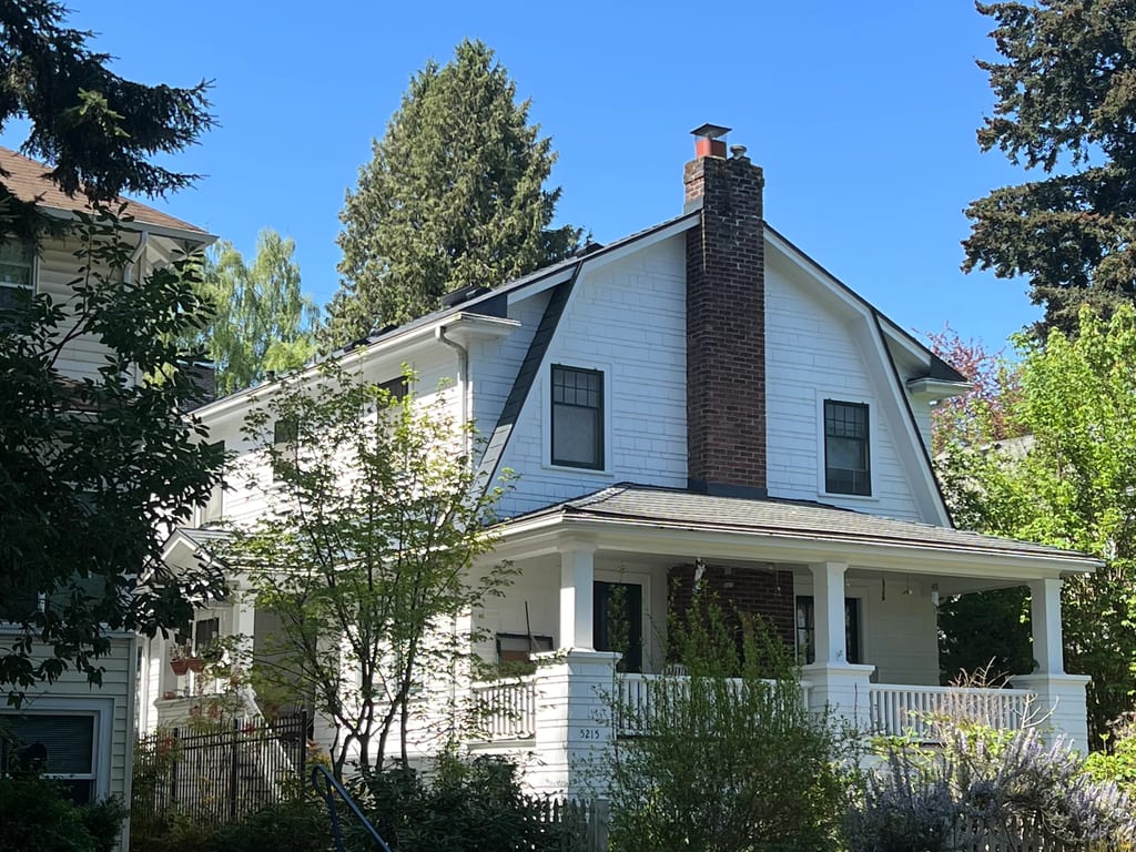 Deep Charcoal Interlock Cedar Shingle aluminum roof on a white two-storey craftsman home with a covered porch, Seattle, Washington