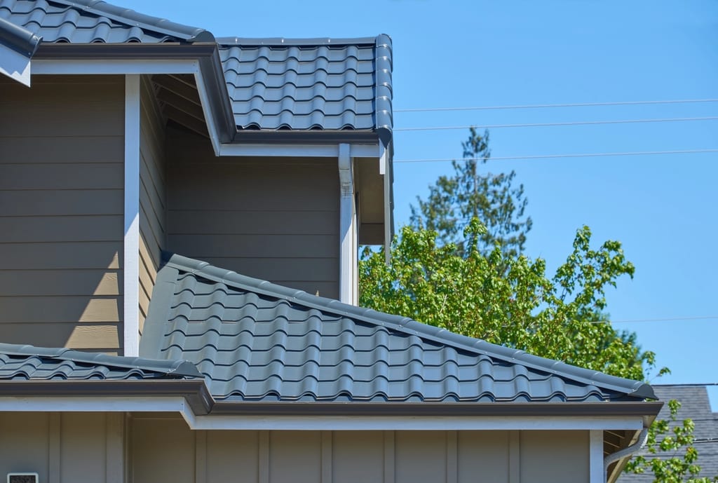 Deep Charcoal Interlock Tile aluminum roof on a Deep Charcoal metal roof on a tan two-storey ranch house, Lynnwood, Washington