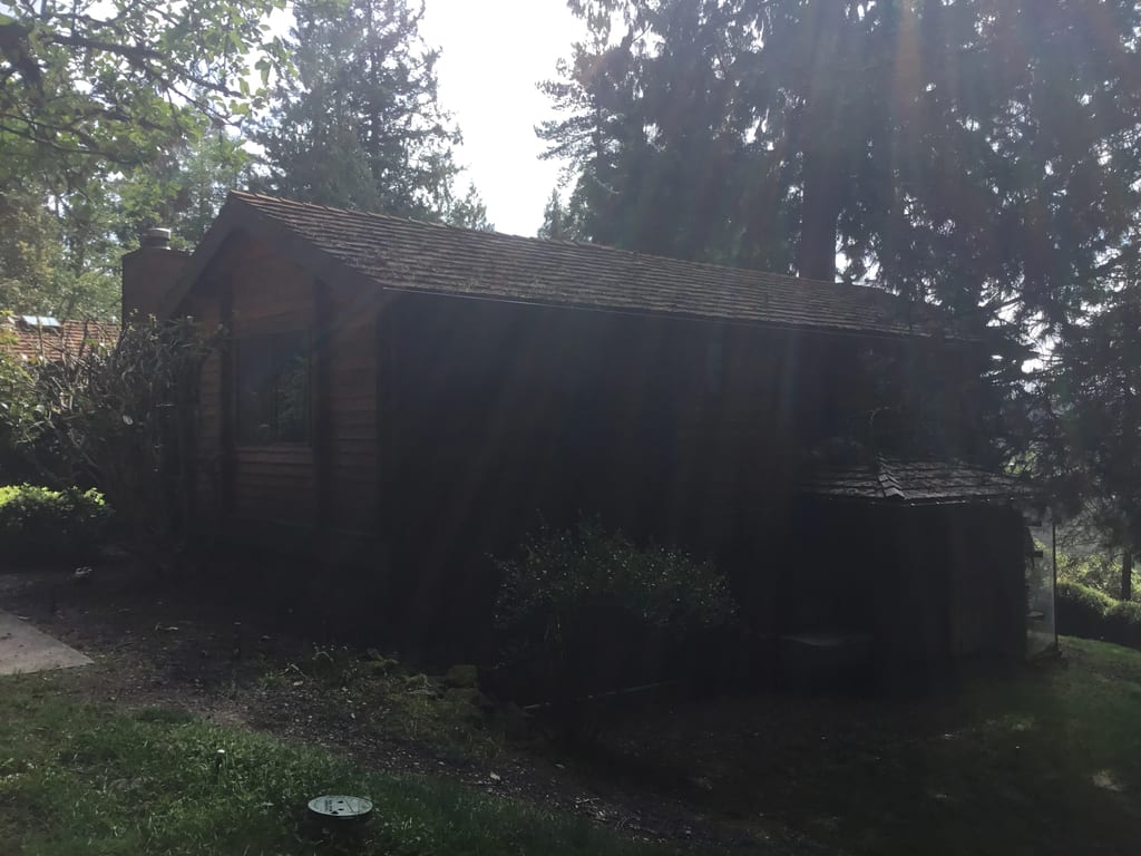 Before: a worn out wood shake roof on the home, Bainbridge Island, Washington, ahead of a Copper Penny Interlock Shake aluminum roof