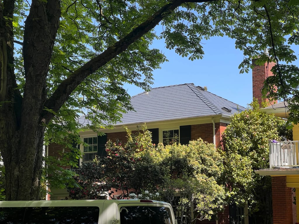 Deep Charcoal Interlock Slate aluminum roof on a red brick home with a metal roof in a urban area, Seattle, Washington