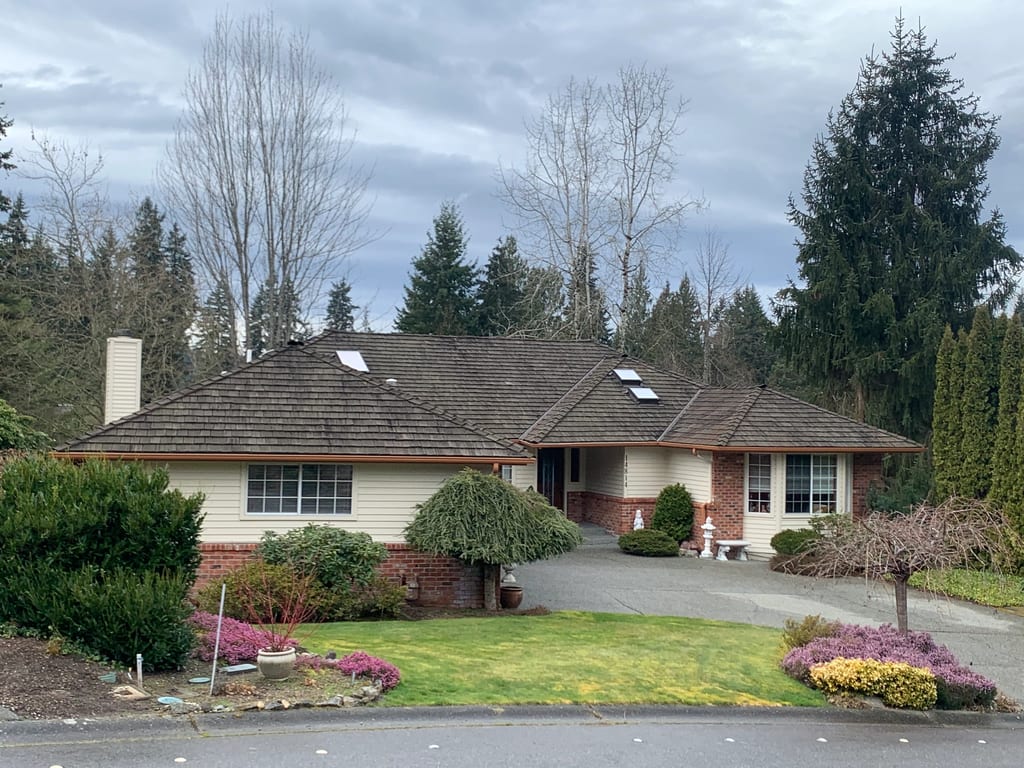 Before: a worn out wood shake roof on the home, Mill Creek, Washington, ahead of a Tudor Brown Interlock Cedar Shingle aluminum roof