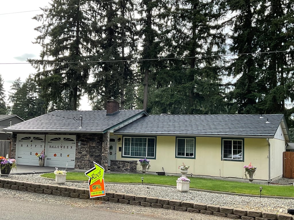 Deep Charcoal Interlock Shake aluminum roof on a single-storey ranch with stone and siding among tall trees, Kent, Washington