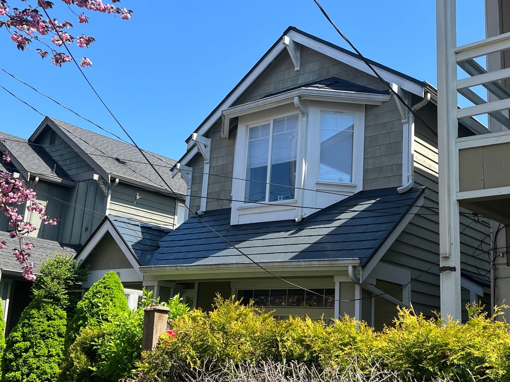 Deep Charcoal Interlock Slate aluminum roof on a grey two-storey home with dormers in a Seattle suburb, Seattle, Washington