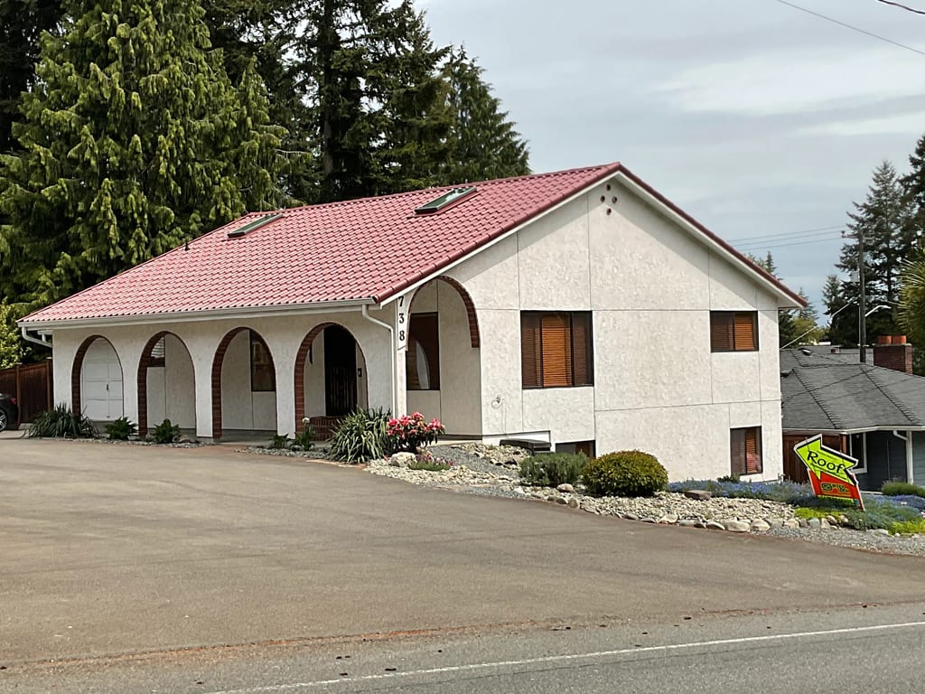 Tile Red Interlock Tile aluminum roof on a white single-family home with red tile roof in a forested, Shoreline, Washington