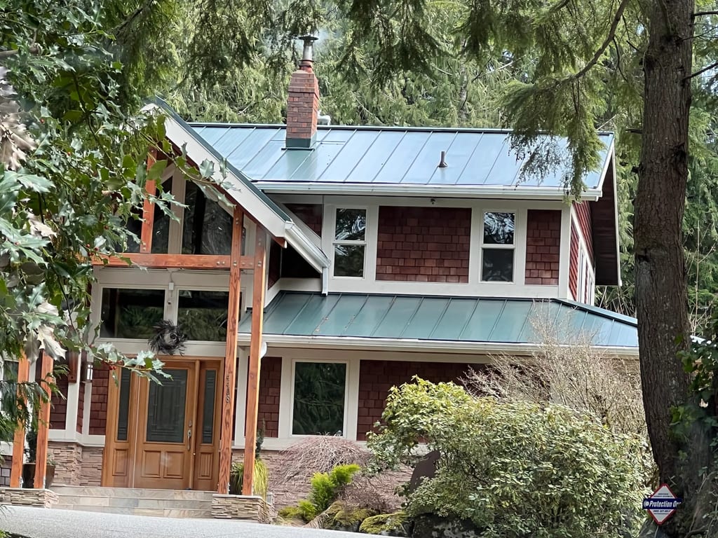 Hunter Green Interlock Standing Seam aluminum roof on a hunter green chalet with a green metal roof in a forested, Fall City, Washington