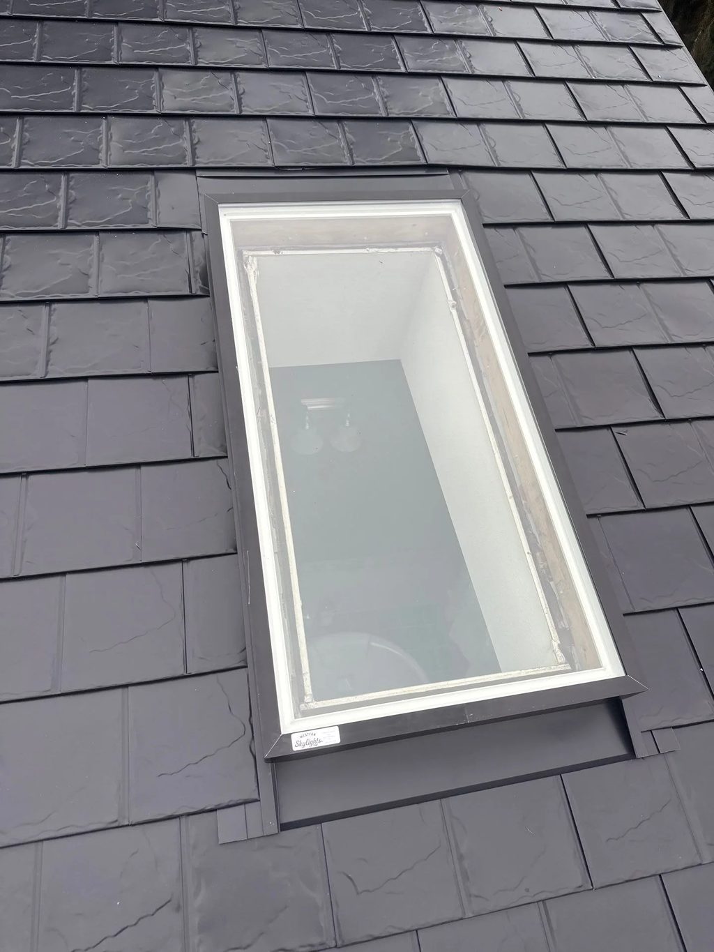 Black Interlock Slate aluminum roof on a house with a slate metal roof in a forested suburban area, Redmond, Washington