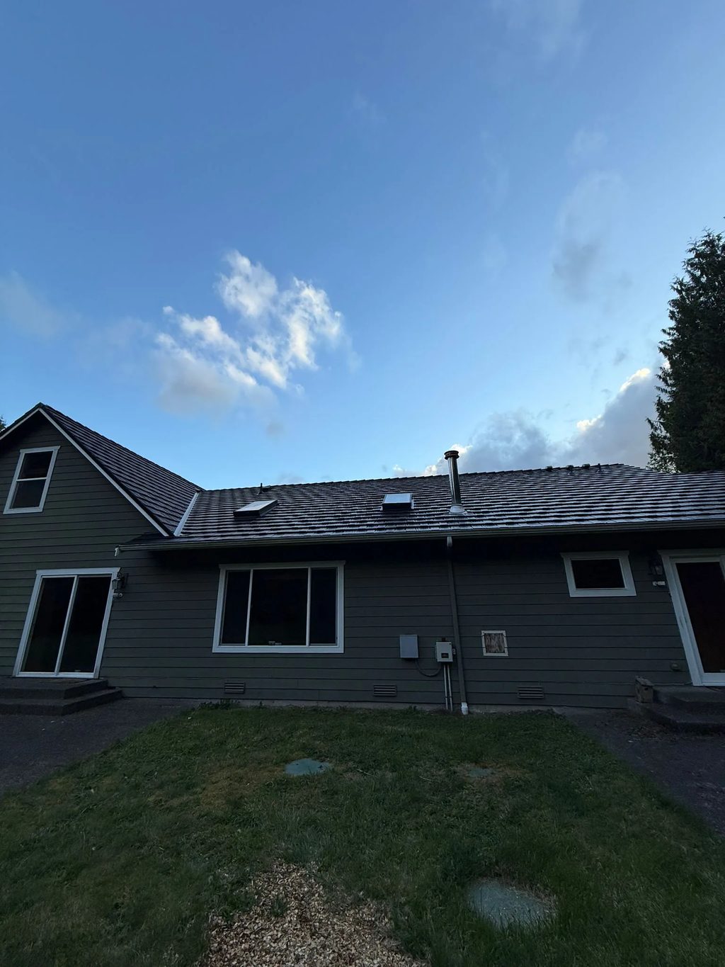 Black Interlock Shake aluminum roof on a black home with a metal roof among tall trees, Marysville, Washington