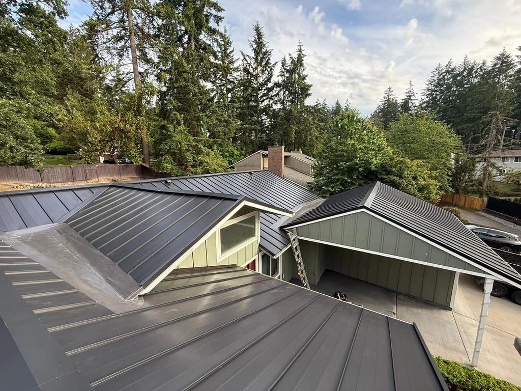 Black Interlock Standing Seam aluminum roof on a modern home with a black metal roof in a forested setting, Lakewood, Washington