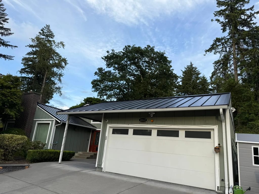 Black Interlock Standing Seam aluminum roof on a green single-family home with a metal roof in a forested, Lakewood, Washington