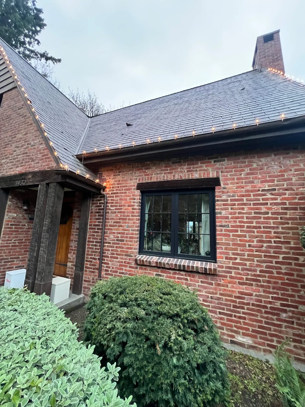 Deep Charcoal Interlock Slate aluminum roof on a red brick home with a metal roof in an urban setting, Seattle, Washington