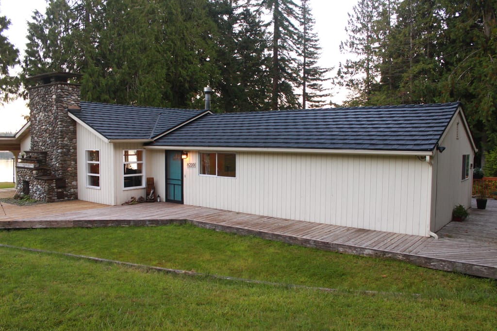 Black Interlock Shake aluminum roof on a white ranch home with a black metal roof in a forested, Shelton, Washington