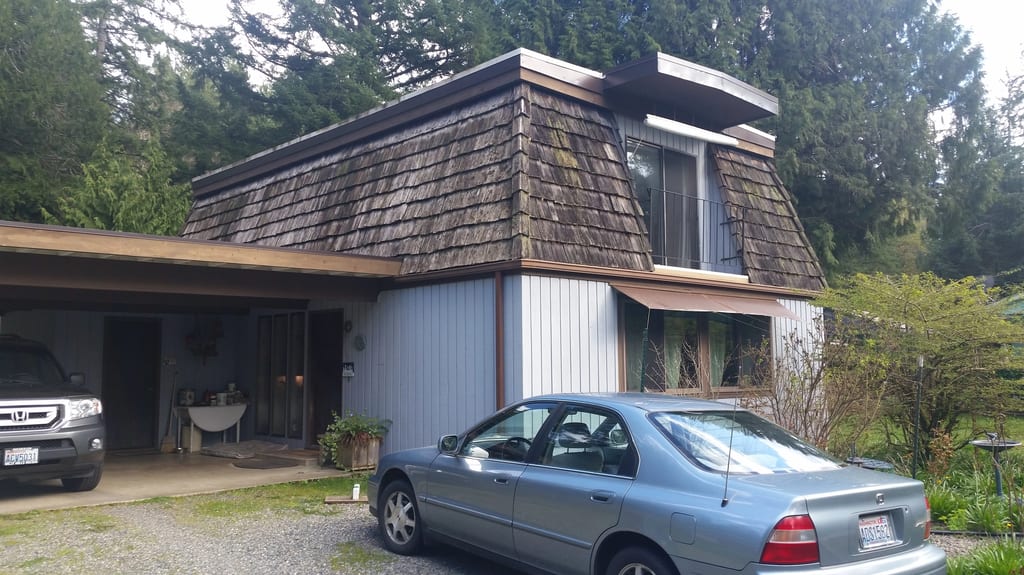 Before: a worn out wood shake roof on the home, Allyn, Washington, ahead of a Tudor Brown Interlock Slate aluminum roof