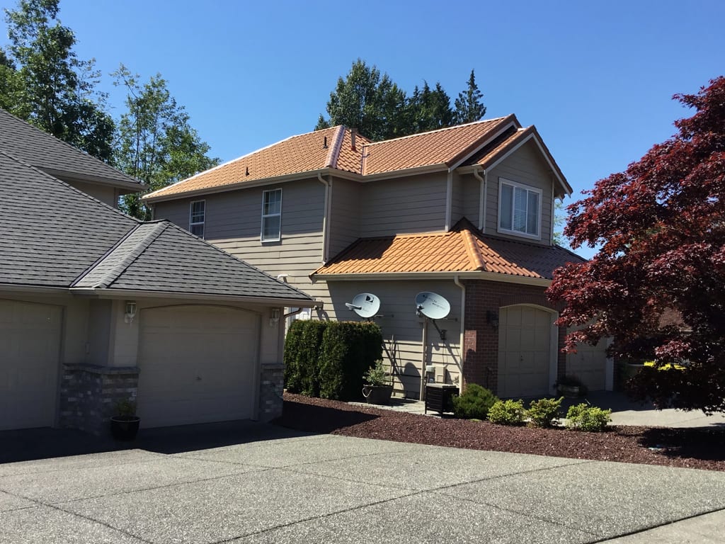Aged Copper Interlock Tile aluminum roof on a two-storey home with a metal roof and dormers in a, Arlington, Washington