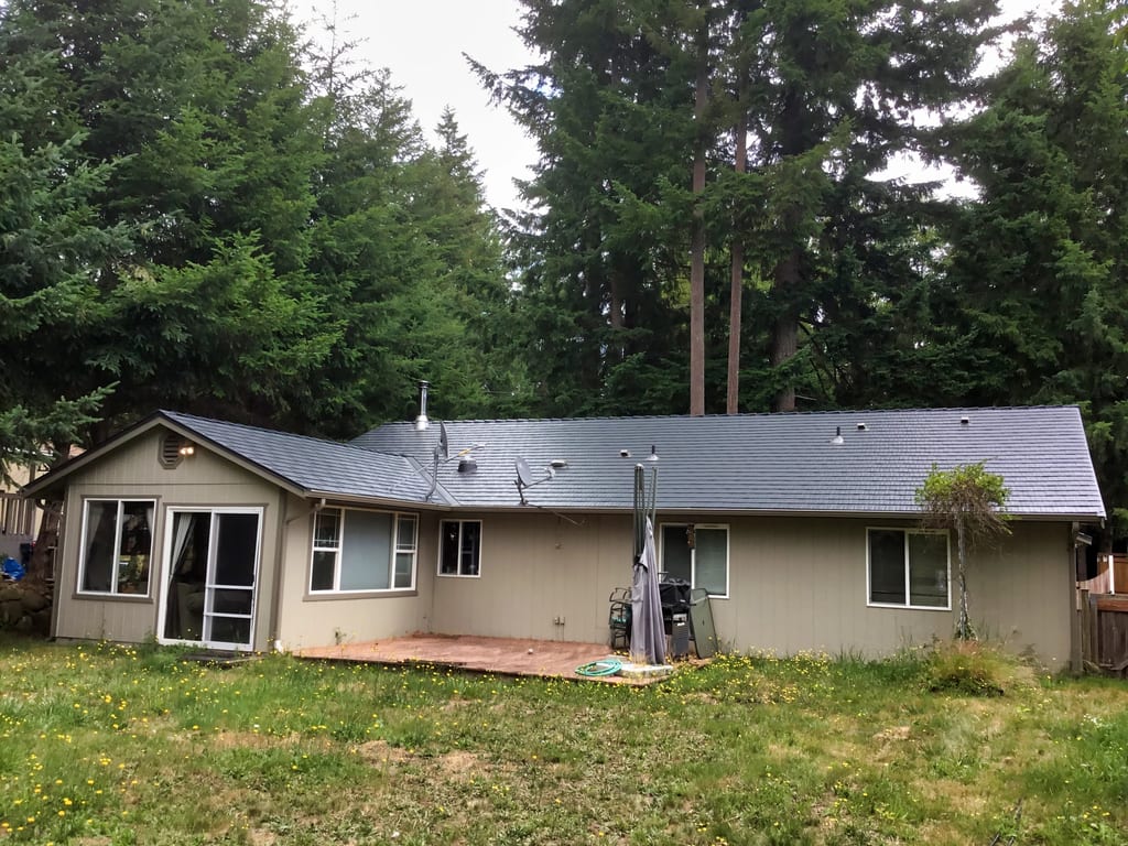 Deep Charcoal Interlock Cedar Shingle aluminum roof on a tan ranch home with a metal roof in a forest clearing, Tenino, Washington