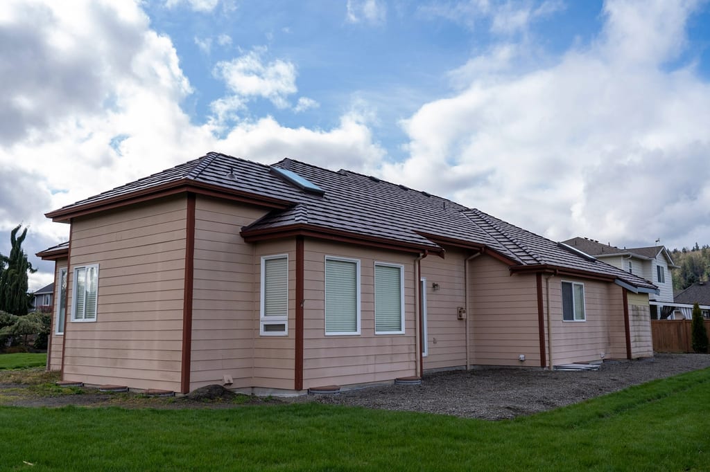 Colonial Brown Interlock Shake aluminum roof on a colonial home with a brown metal roof among tall green, Orting, Washington