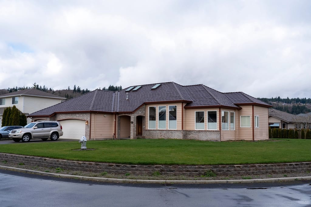 Colonial Brown Interlock Shake aluminum roof on a Colonial brown home with two stories on a suburban street, Orting, Washington