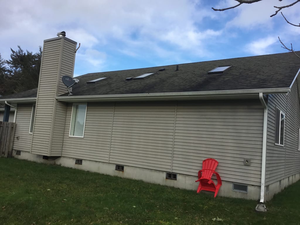 Before: a worn out asphalt shingle roof on the home, Ocean Shores, Washington, ahead of a Black Interlock Slate aluminum roof