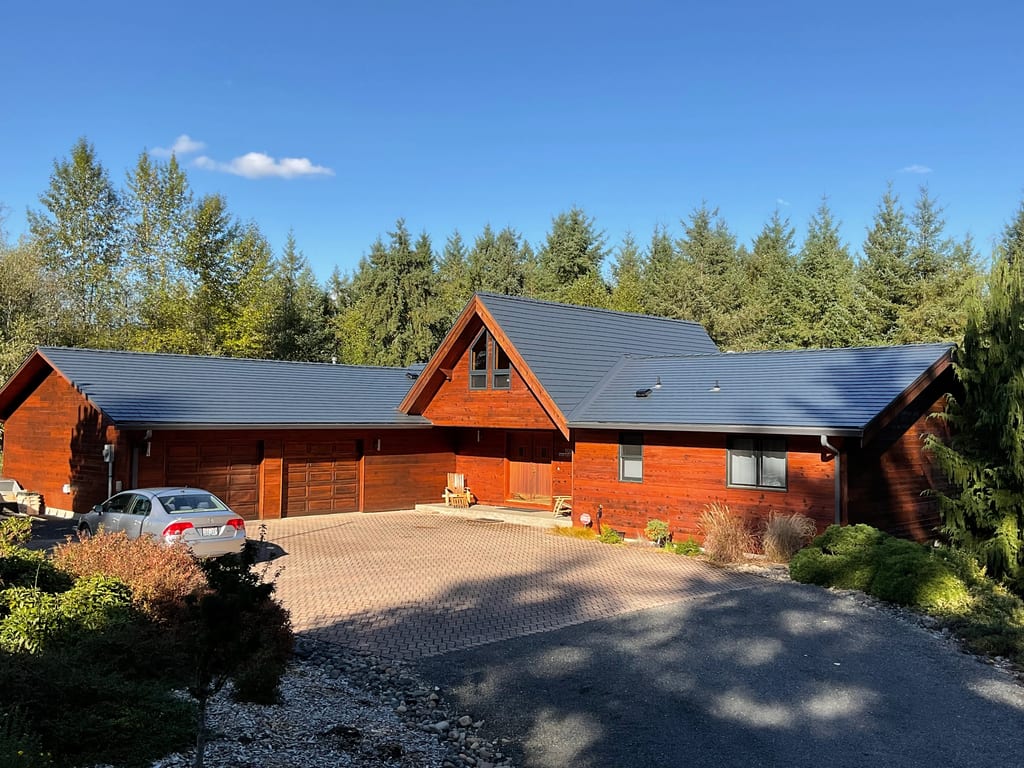 Deep Charcoal Interlock Cedar Shingle aluminum roof on a brown single-family home with a metal roof among tall, Olympia, Washington