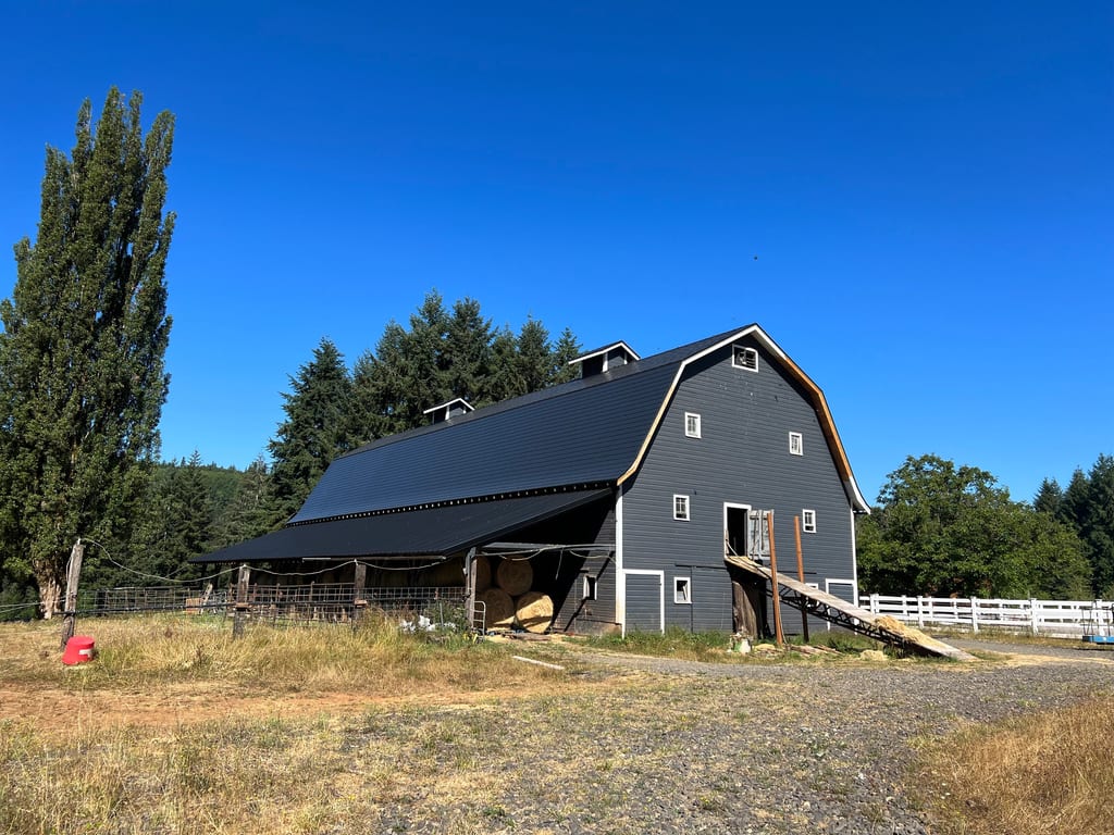 Black Interlock Slate aluminum roof on a black two-storey home with dormers on a rural farm, Longview, Washington