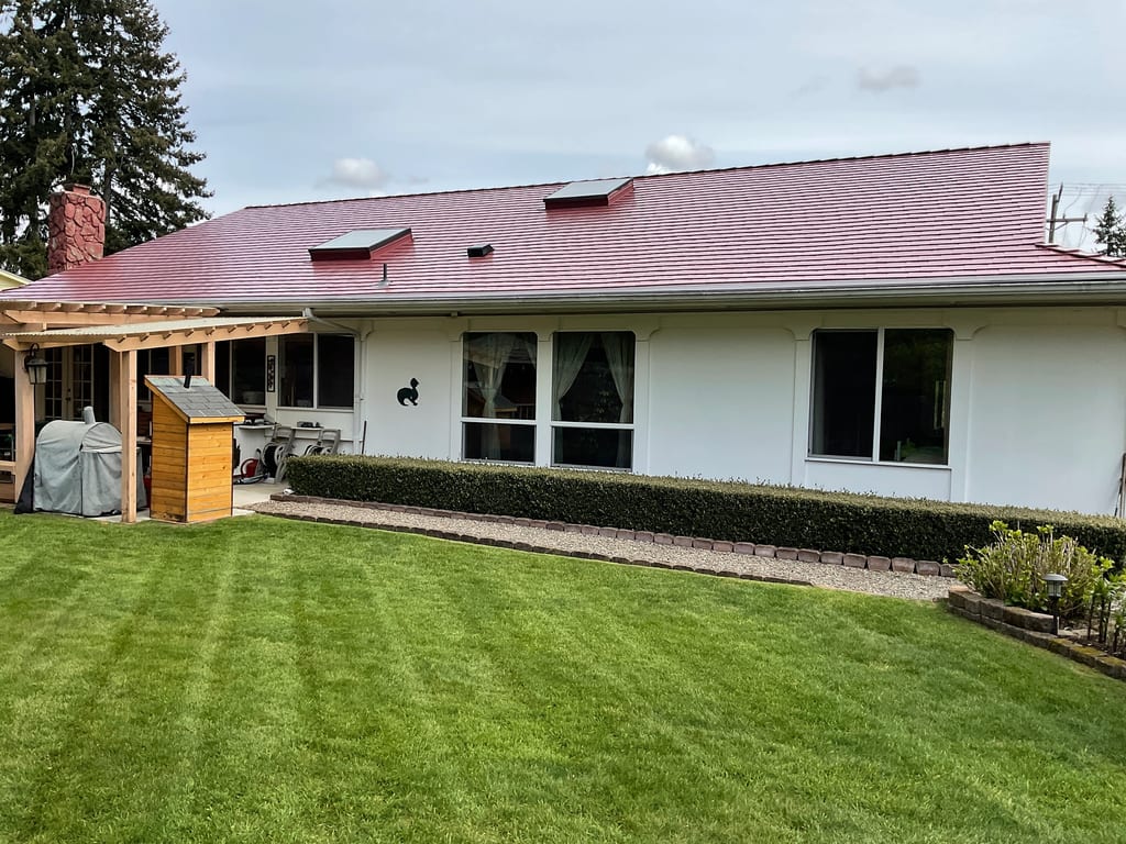 Tile Red Interlock Slate aluminum roof on a white one-storey home with a red metal roof in a, Lakewood, Washington