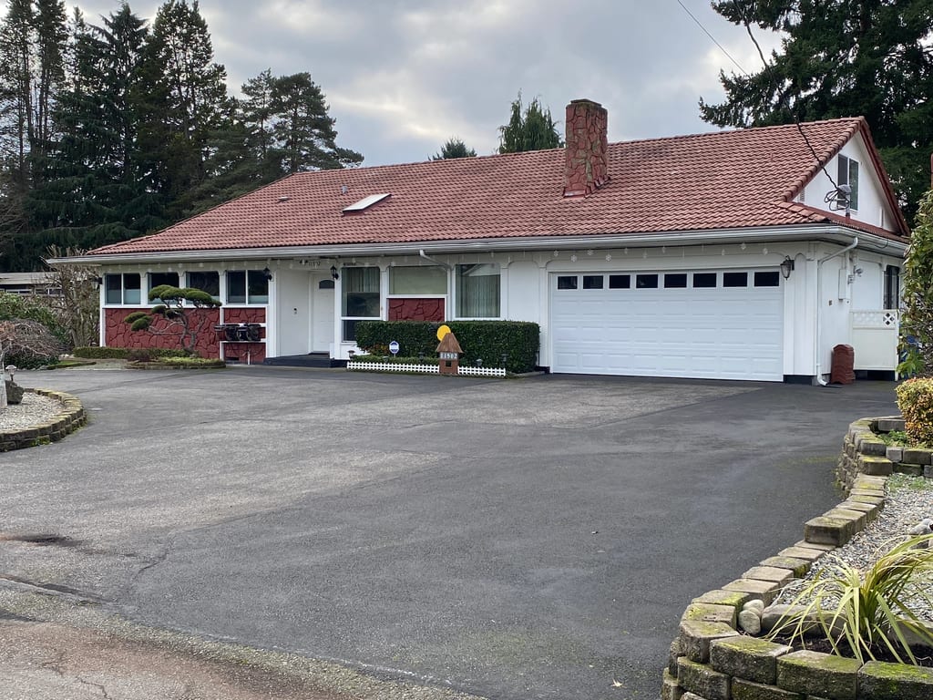 Before: a worn out concrete tile roof on the home, Lakewood, Washington, ahead of a Tile Red Interlock Slate aluminum roof