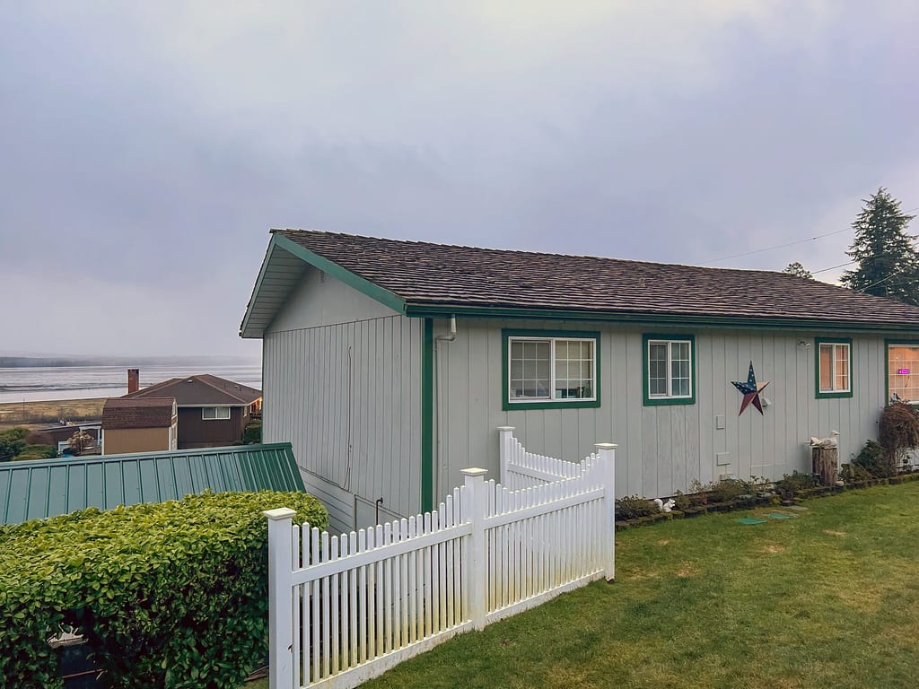Before: a wind damaged wood shake roof on the home, Hoquiam, Washington, ahead of a Copper Penny Interlock Cedar Shingle aluminum roof