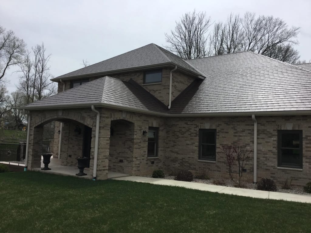 Colonial Brown Interlock Slate aluminum roof on a brown Colonial home with dormers in a wooded area, Horicon, Wisconsin