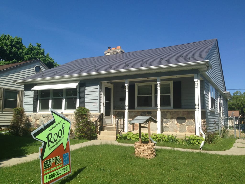 Weathered Interlock Slate aluminum roof on a light blue ranch home with a stone front among green lawns, Milwaukee, Wisconsin
