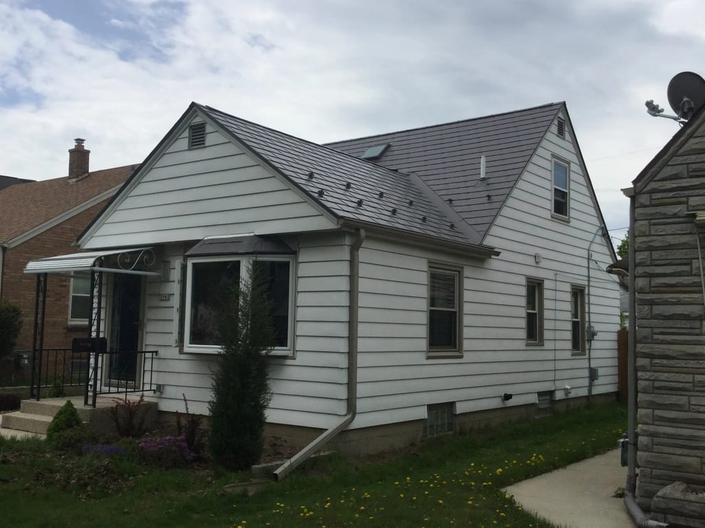Weathered Interlock Slate aluminum roof on a white single-family home with dormers in an urban, Milwaukee, Wisconsin