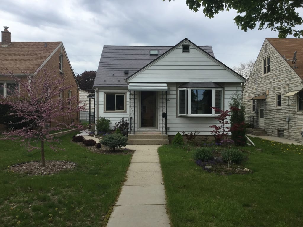 Weathered Interlock Slate aluminum roof on a white single-storey home with dormers among suburban, Milwaukee, Wisconsin