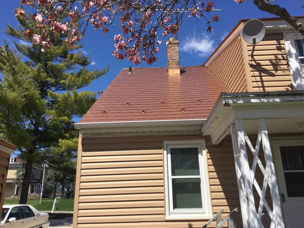 Aged Copper Interlock Slate aluminum roof on a tan single-family home with a copper metal roof and white, Watertown, Wisconsin