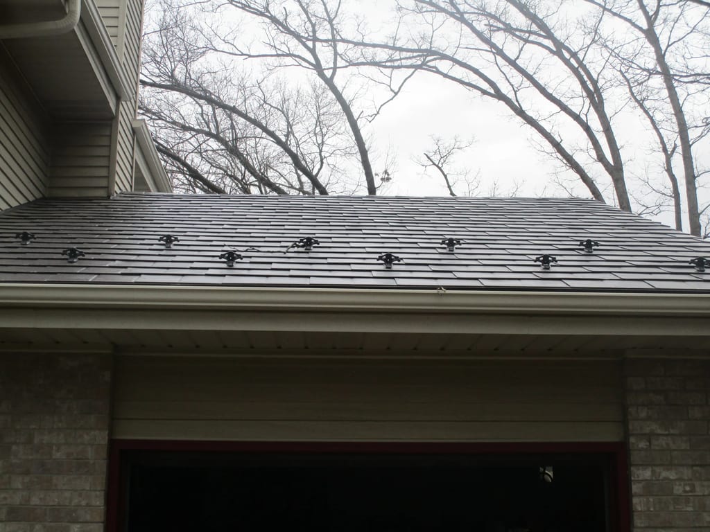 Tudor Brown Interlock Slate aluminum roof on a two-storey Tudor home in a wooded setting, Delafield, Wisconsin