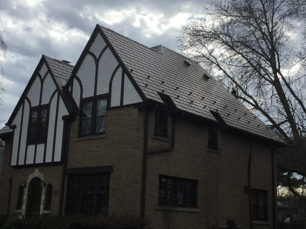 Colonial Brown Interlock Slate aluminum roof on a brown colonial home with dormers in a forested setting, Milwaukee, Wisconsin