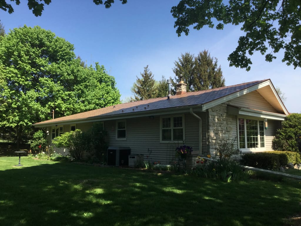 Aged Copper Interlock Slate aluminum roof on a gray ranch home with a stone facade and metal roof in a, Colgate, Wisconsin