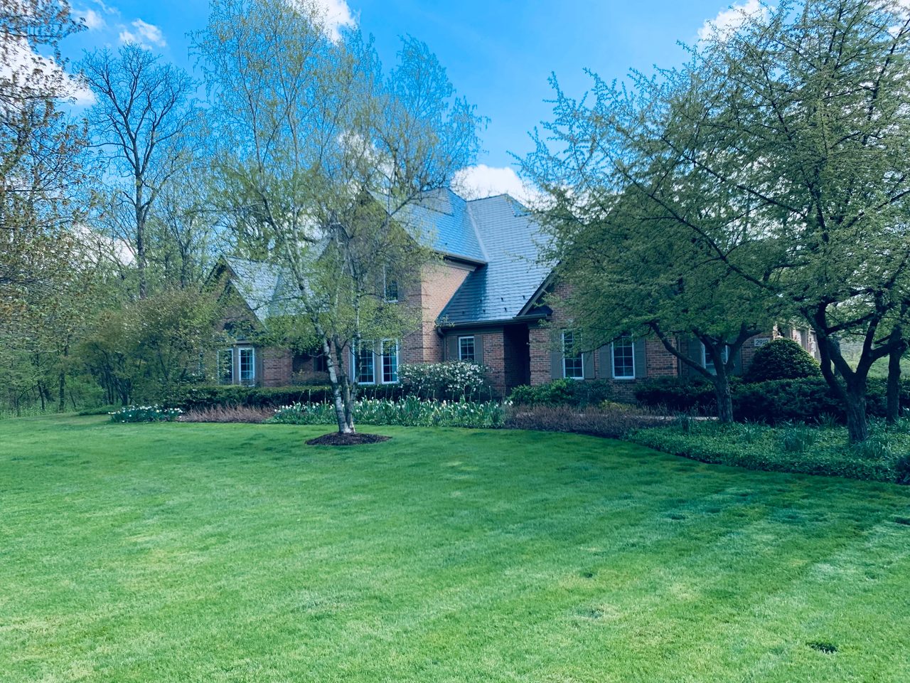 Deep Charcoal Interlock Slate aluminum roof on a brick two-storey colonial home among trees in Crystal Lake, Crystal Lake, Illinois