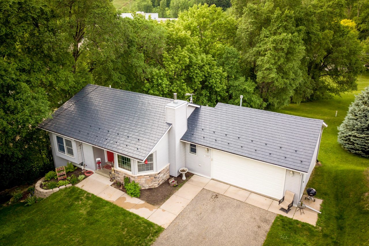 Deep Charcoal Interlock Slate aluminum roof on a white home with a deep charcoal metal roof among tall, Red Wing, Minnesota