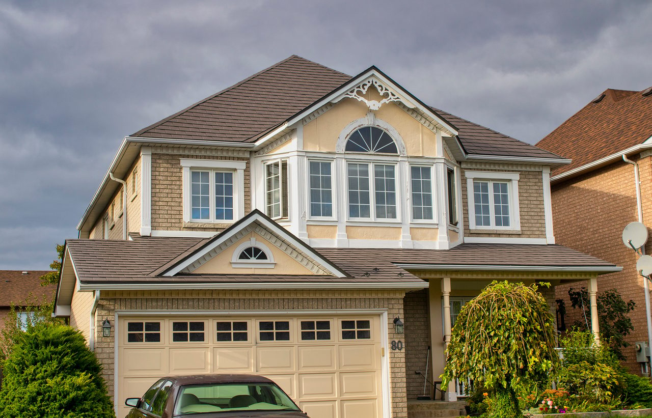 Two-storey colonial suburban home in Ajax ON with Interlock aluminum slate roof in Musket Grey featuring multi-hip complexity and decorative dormer gable.