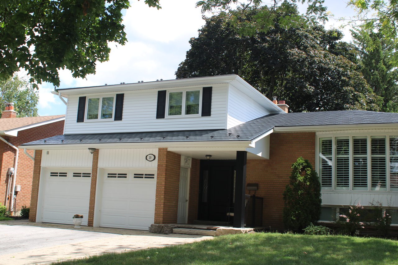 Two-storey brick Colonial home in Paris, ON with Interlock deep charcoal aluminum slate roof, box dormer, double garage, and black shutters.