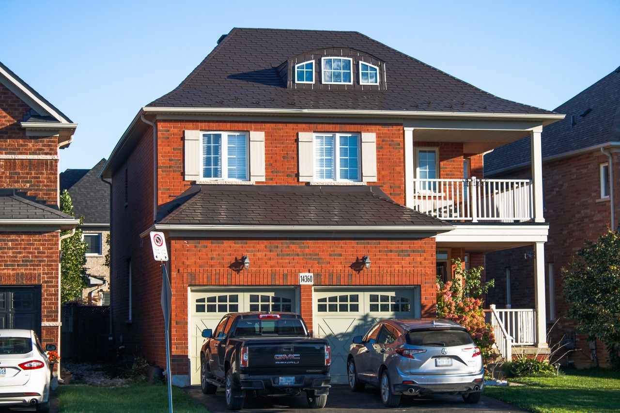Two-storey brick home in Georgetown ON with Interlock Tudor Brown aluminum slate roof, multi-hip profile, and center dormer.