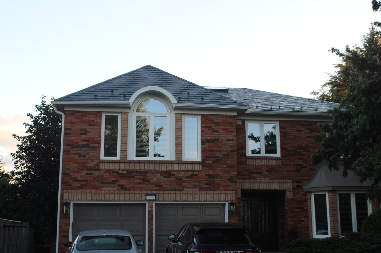 Two-storey brick Colonial home in Oakville with Interlock deep charcoal aluminum slate metal roof featuring multi-hip profile and snow guards.