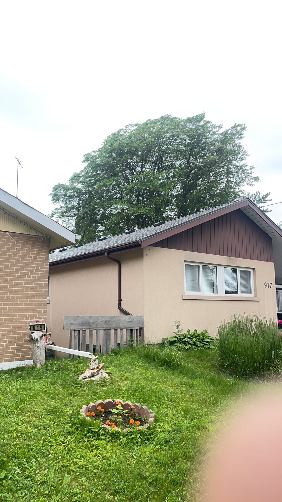 Single-storey ranch home at 917 with Interlock Musket Grey aluminum slate roofing on a simple gable, stucco exterior, Scarborough ON.