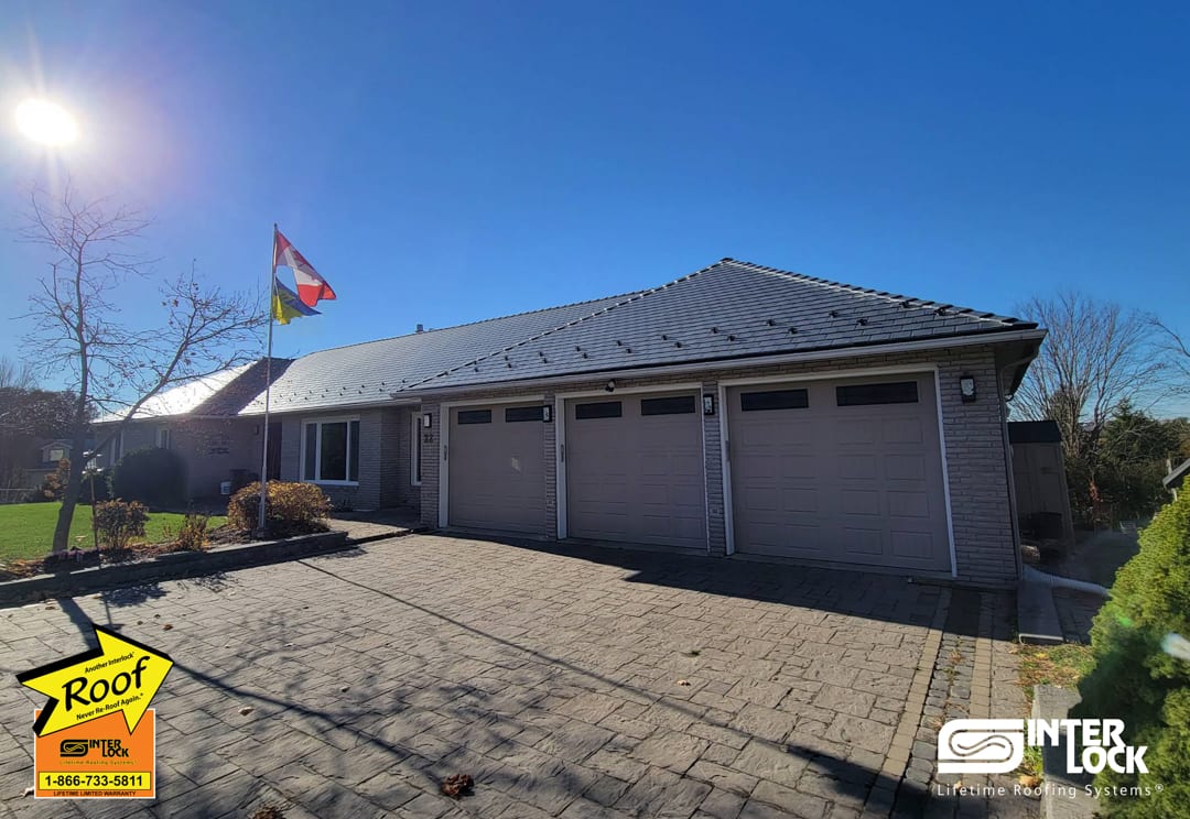 Single-storey ranch home in Nepean, ON with Interlock deep charcoal aluminum slate metal roofing on a hip roof, three-car garage, and brick exterior.
