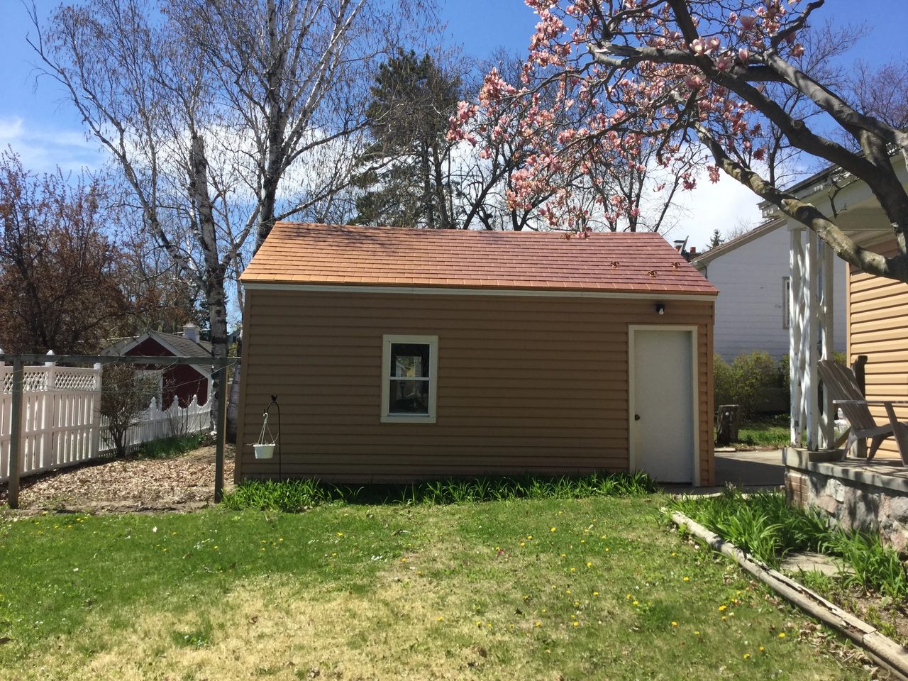 Aged Copper Interlock Slate aluminum roof on a two-storey home with a metal roof among tall trees, Watertown, Wisconsin