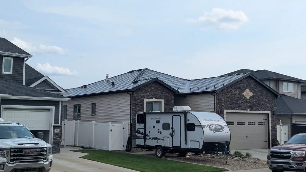 Black Interlock Slate aluminum roof on a black house with a metal roof in a rural area, Medicine Hat, Alberta
