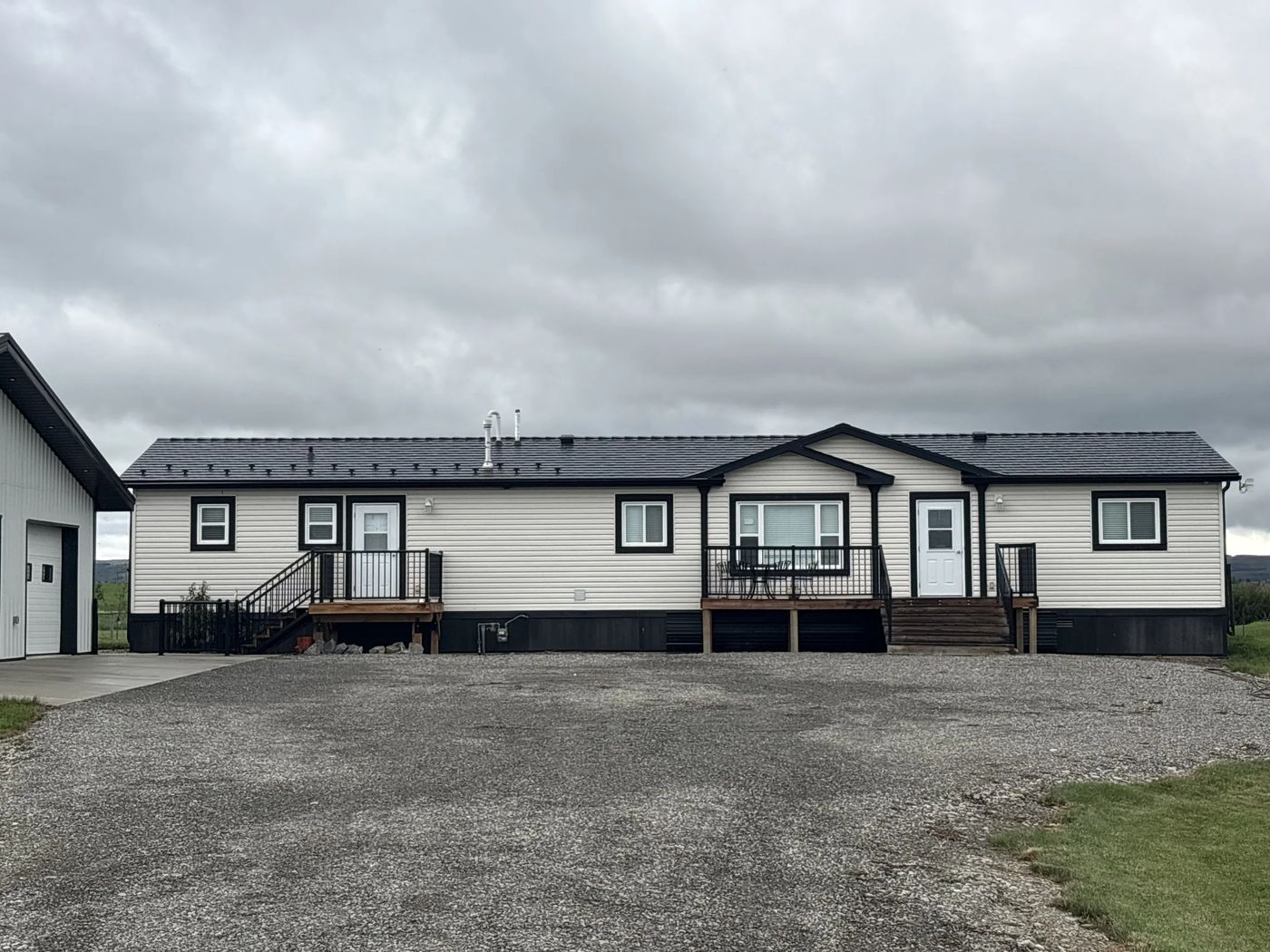 Black Interlock Cedar Shingle aluminum roof on a white ranch home with a black metal roof in a rural, Foothills County, Alberta